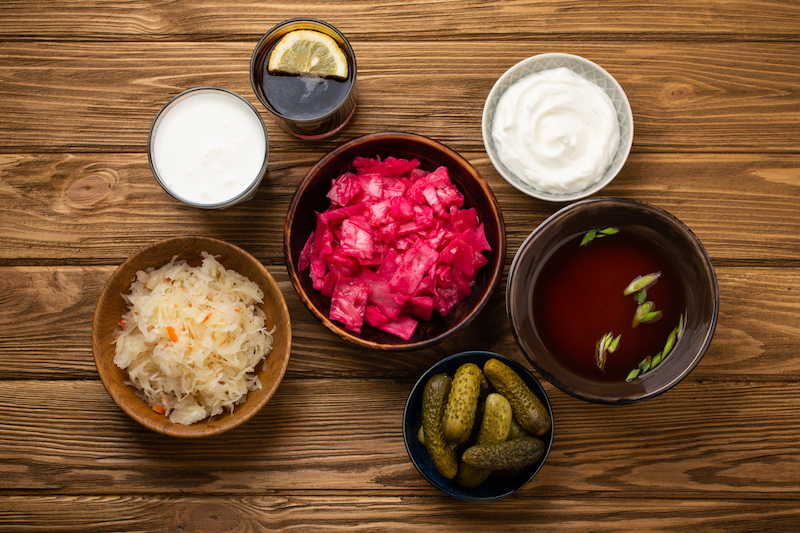 Arrangement mit Sauerkraut, Kimchi, sauren Gurken, Yoghurt, Kefir, Miso Suppe und Kombucha
